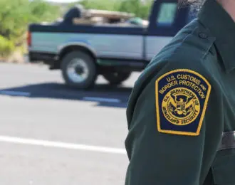 The U.S. Customs and Border Protection uniform patch of an agent standing on a road near an interior checkpoint in Southern Arizona