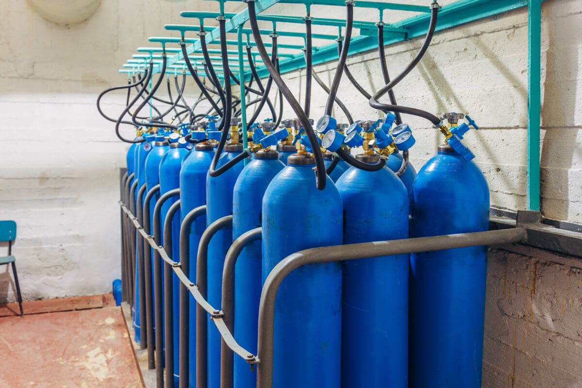Bundle of blue gas cylinders with pressure gauges