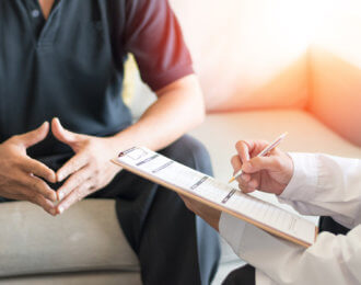 Urologist Doctor giving consult for prostate problems to patient. Urologic oncologists specialize in treating cancer of the urinary tract and male reproductive organs. Mens health problem concept.